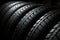 Car tires stacked in abstract arrangement, showcasing tread diversity