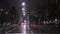 Car travels through night city streets in the rain