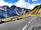 Car trip down hill on Grossglockner alpine scenic road in front of curve in sunny cloudy day