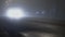 Car truck with switched on headlights driving on a road in the fog at night, bad visibility due to mist