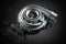 Car turbocharger on black background. Auto part turbo engine technology concept