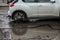 Car tyre about to pass through large pothole full of water