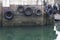 Car tyres hanging on rope against harbour wall at port dock to protect ships and boats