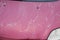 Car used peeling red pink paint on grunge hood of old automobile