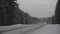 Car view on icy highway after turning off of snow covered trail at high rate of speed passing large grey truck.