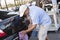 Car wash employee wiping rear of a vehicle