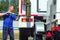 Car wash for heavy and cargo vehicles. Male car washer in washes truck on summer day outside