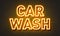 Car wash neon sign on brick wall background.