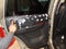 A car wash worker applies foam on the inside of a door to clean the skin.