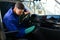 Car wash worker cleaning automobile interior