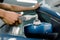 Car wax polishing process. Cropped image of hands of male professional African worker with orbital polisher in auto