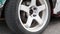 Car wheel on asphalt street racing track. Close up drift racing car in drift playground. The car is equipped with wide body kits a