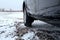 Car wheel with winter tire on the gravel road at winter time