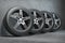 Car wheels. Four new black tyres with alloy discs in garage