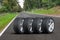 Car wheels set - four car wheels arranged in a row on the asphalt road next to the forest