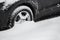 Car wheels stuck in deep snow, after a heavy snowfall, close-up.Snow cyclone.