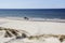 Car at the wide seashore in the clear afternoon