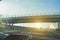 Car window view of trucks speeding in motorway under a overpass bridge with back light - Fast moving vehicles at sunset -