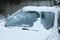 Car windshield with wiper blades cleaned from snow outdoors on winter day