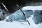 Car windshield with wiper blades cleaned from snow outdoors on winter day