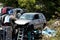 Car wreckage left after accident in local scrap yard on pile of car parts surrounded with densely stacked car bumpers