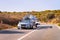 Car with yacht or motor boat at road of Sardinia