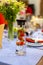 A carafe filled with water and strawberries stands on a served blue table. close up, soft focus. served table is on