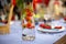 a carafe filled with water and strawberries stands on a served blue table.  close up, soft focus. served table is on background in