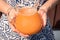 carafe of orange juice with pulp in the hands of a young girl