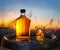 Carafe of whisky and glass of whisky with ice cubes on old wooden cask. Beautiful sunset at the background