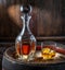 Carafe of whisky and glass of whisky on old wooden cask at the dark background