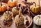 Caramel apples coated with nuts with autumn background