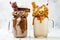 Caramel and chocolate crazy freakshake milkshakes with brezel waffles, popcorn, marshmallow, ice cream and whipped cream.