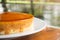 Caramel custard cake on white plate. Sweet and moist dessert.