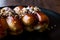 Caramel Eclairs with Hazelnut and cream in black plate.