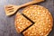 Caramel macadamia tart baked in a buttery homemade shortcrust pastry closeup in the board. Horizontal top view