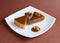 Caramel nuts tartlet pieces on white plate