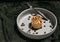 Caramel Pecanbon topped with decadent caramel frosting and pecans and served with Coffee beans and Metal fork on ceramic plate