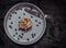 Caramel Pecanbon topped with decadent caramel frosting and pecans and served with Coffee beans and Metal fork on ceramic plate