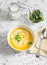 Caramelized golden beet and fall roots soup on a light background, top view.