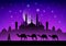 caravan of camels in the desert near the mosque under the moon