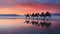 Caravan of camels on the salt lake at sunrise