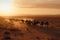 Caravan of Camels trekking through a Mystical Desert Landscape at Sunset