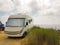 Caravan car by the sea in autumn season cloudy blue ksy grass in preveza greece