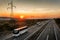 Caravan of Four buses in line traveling on a highway at sunset