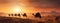 a caravan of Indian camels, led by experienced camel drivers, traversing the mesmerizing desert sand dunes at sunset