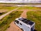 Caravan solar panels on roof camping on lake shore. Aerial view