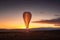 carbon dioxide balloon rising into the air, with sunset in the background
