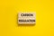 Carbon regulation symbol. Concept words Carbon regulation on wooden blocks on a beautiful yellow table yellow background. Business