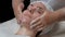 Carboxytherapy. Portrait of a beautiful European girl in a beauty salon on a facial treatment. The female hands of the